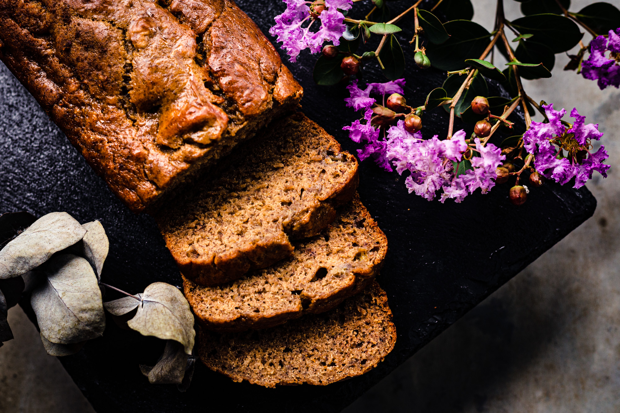 loaf and slices of banana bread with purple flowers