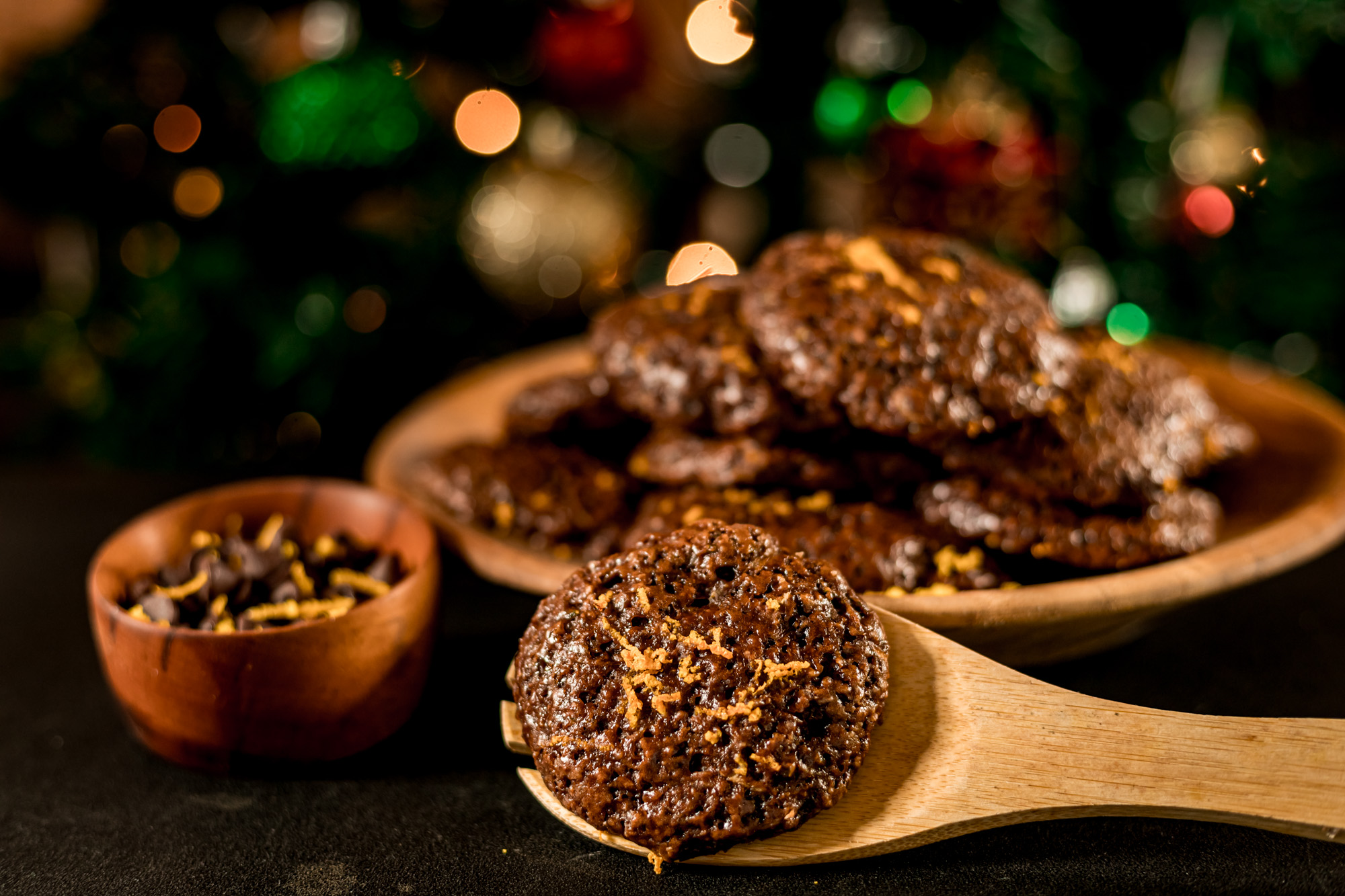 chocolate orange cookies in front of a christmas tree